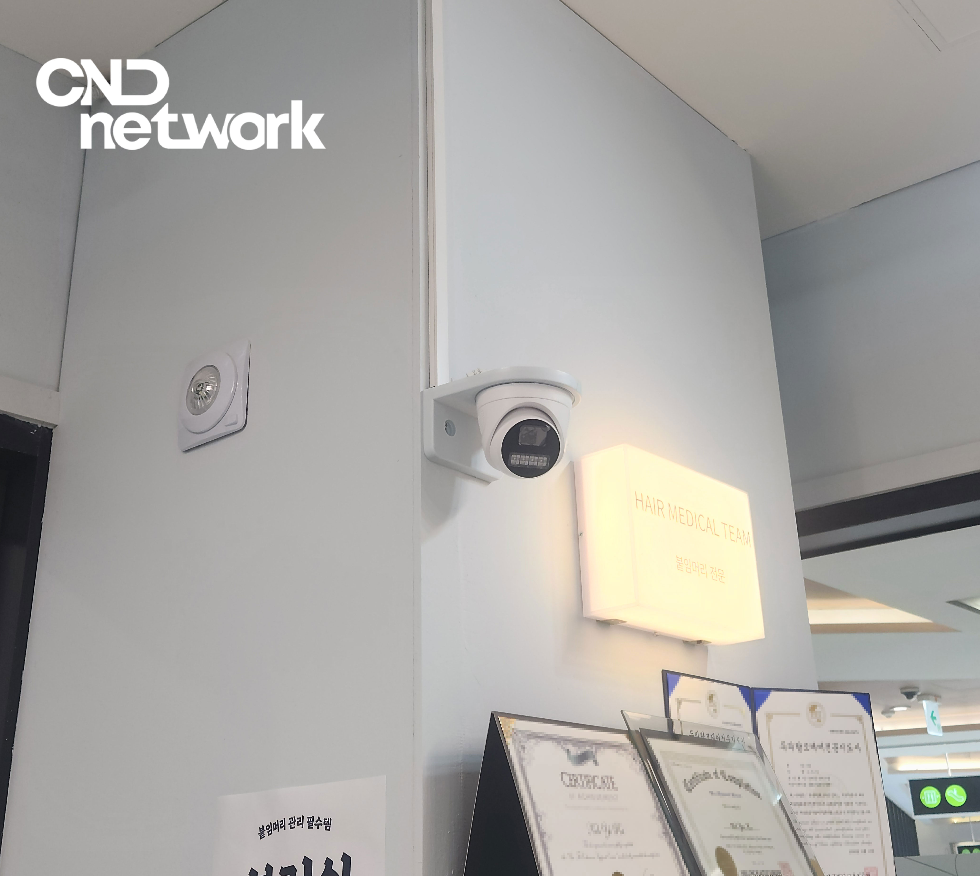 인증서 진열장 상단 미용실 CCTV 설치 모습, 조명 옆 안전한 위치 선정